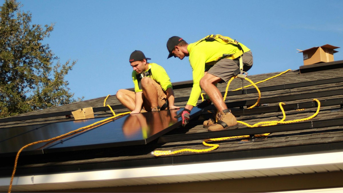 Installation team fitting solar panels on a roof